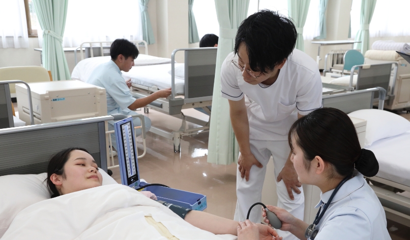 ベットで寝ている女性を看護する様子